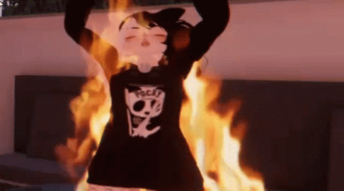 Person In Black Sweater With Skull Standing In Front Of Fire GIF