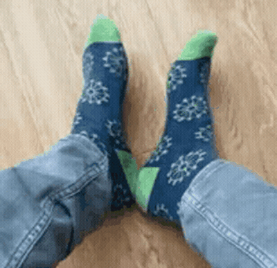 Person In Blue And Green Socks With Snowflakes GIF