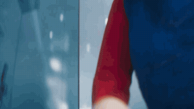 Person In Blue And Red Shirt Standing In Front Of Window GIF