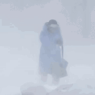 Person In Blue Coat Walking Through Snow GIF