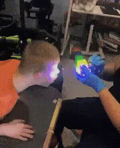 Person In Blue Gloves Holding Rainbow Light GIF