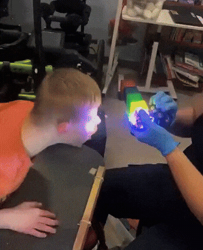 Person In Blue Gloves Holding Rainbow Toy GIF