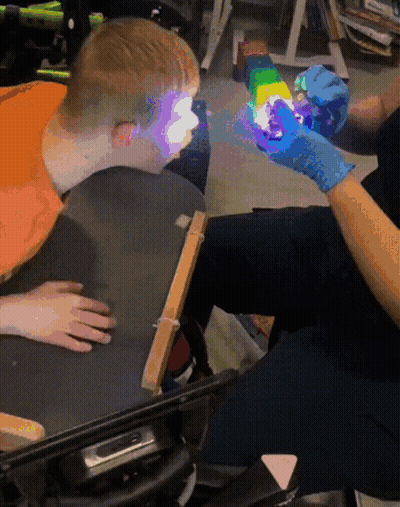 Person In Blue Gloves Holding Rainbow Toy GIF