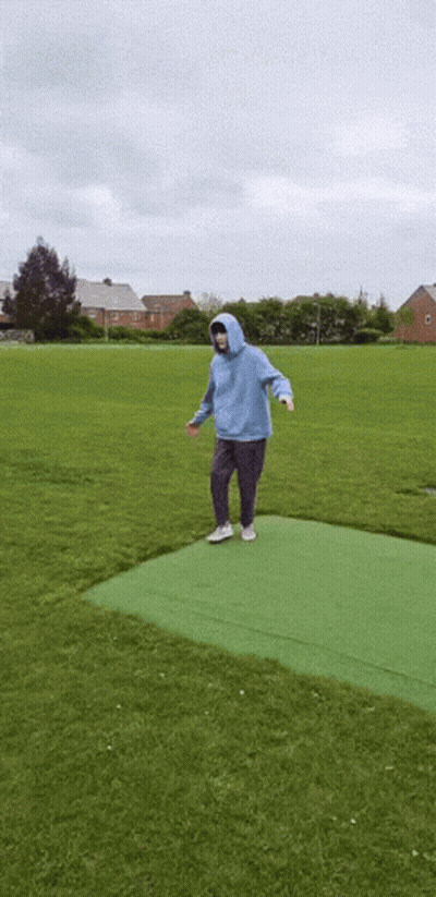 Person In Blue Hoodie Standing On Green Carpet In Field GIF