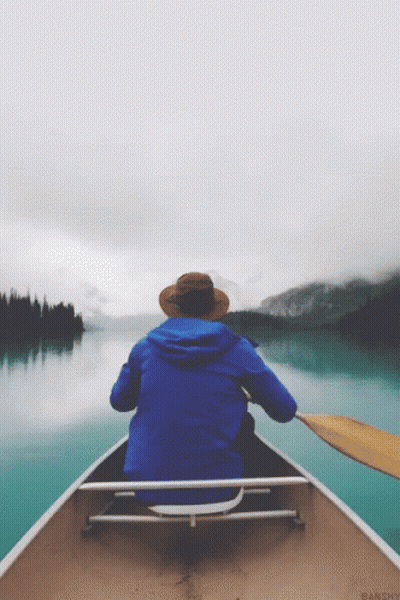 Persona con chaqueta azul y sombrero en canoa GIF