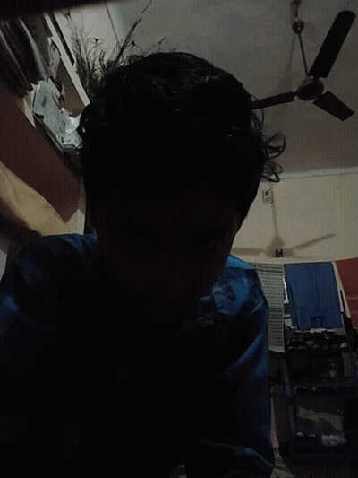 Person In Blue Shirt Standing In Front Of Fan GIF
