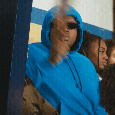 Person In Blue Sweater Holding Colorful Object GIF