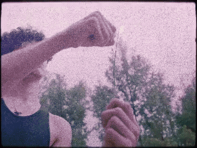 Person In Blue Tank Top Holding Item GIF