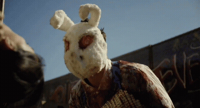 Person in Bunny Mask in Front of Graffiti