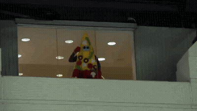 Person In Costume Standing On Balcony Looking Out Window GIF