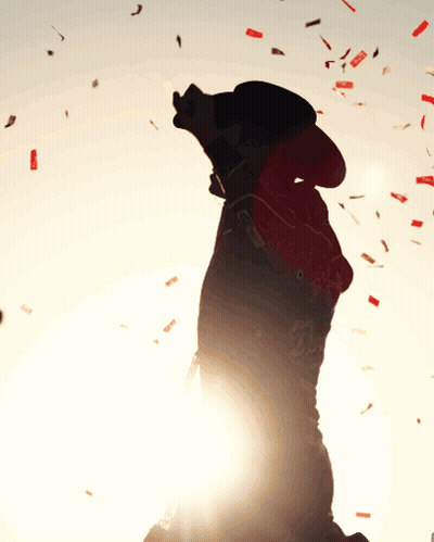 Person In Cowboy Hat Blowing Confetti GIF