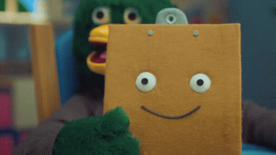 Person In Green Bird Costume Holding Cardboard Box With Smiley Face GIF