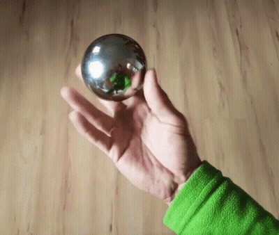 Person In Green Shirt Holding Metal Ball GIF