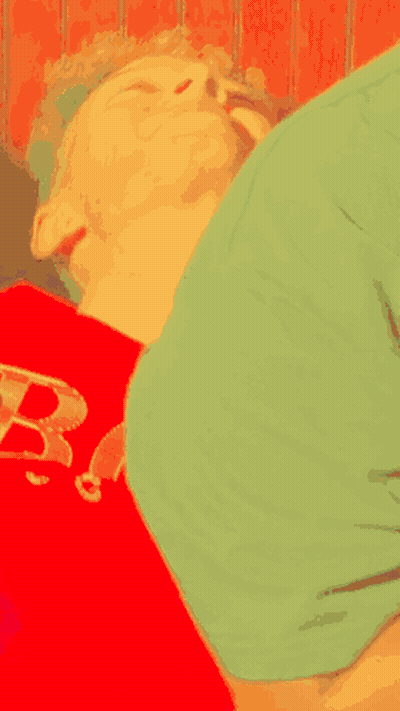Person In Green Shirt Lying On Red Shirt With Letter B GIF