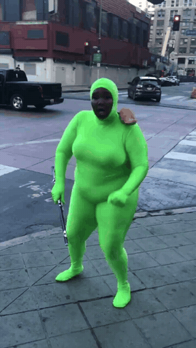 Person In Green Suit Walking Down Street GIF