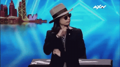 Person In Hat And Sunglasses With AXN On Blue Background GIF