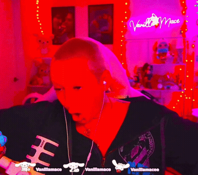 Person In Headphones And Mask In Front Of Vanilla Mac Neon Sign GIF