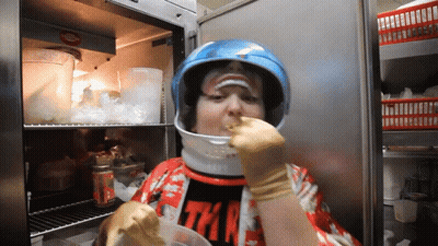 Person In Helmet Eating From Container GIF