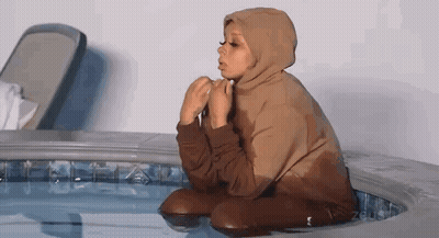 Person In Hoodie Kneeling In Hot Tub GIF