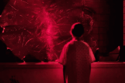 Person In Hospital Gown In Front Of Red Light GIF