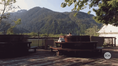 Person In Hot Tub With Mountains And SCM Logo GIF