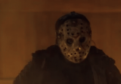 Person In Jason Voorhees Mask Standing In Front Of Fire GIF