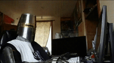Person In Knight's Helmet At Computer GIF