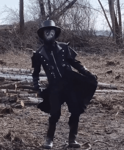 Person In Mask And Hat In Log Field GIF