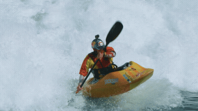 Person In Orange And Yellow Kayak Going Through Wave GIF