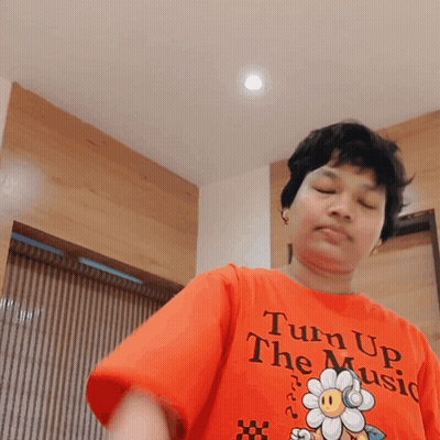 Person In Orange Shirt Says Turn Up The Music GIF