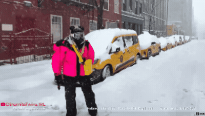 Person In Pink Jacket In Front Of Snow-Covered Taxi Cabs GIF