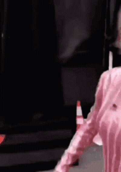 Person In Pink Shirt Next To Traffic Cone GIF