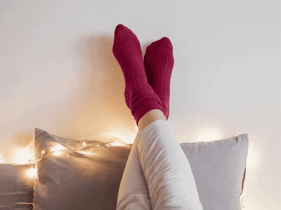 Person In Pink Socks Sitting On Bed GIF