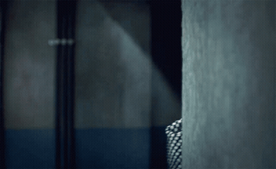 Person In Plaid Shirt Standing In Dark Room GIF