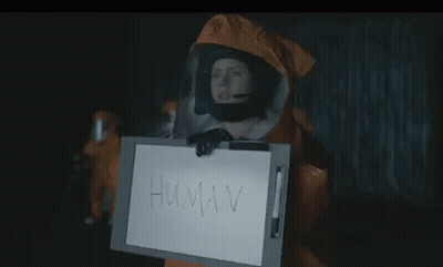 Person In Protective Suit Holding Sign Saying Human GIF