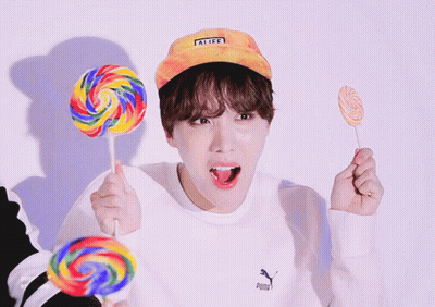 Person in Puma Sweatshirt Holding Three Lollipops