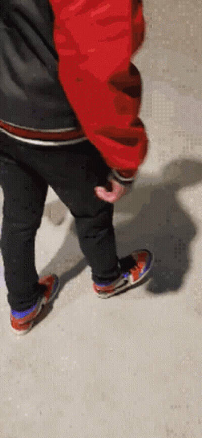 Person In Red Jacket And Black Jeans Standing On Concrete GIF