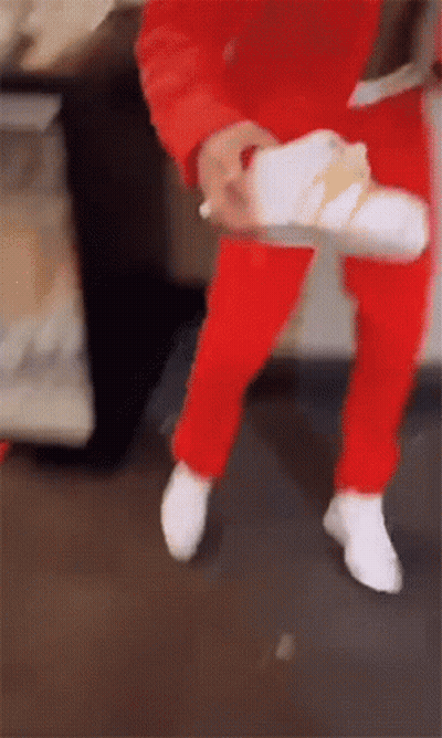 Person In Red Pants Holding White Shoe GIF