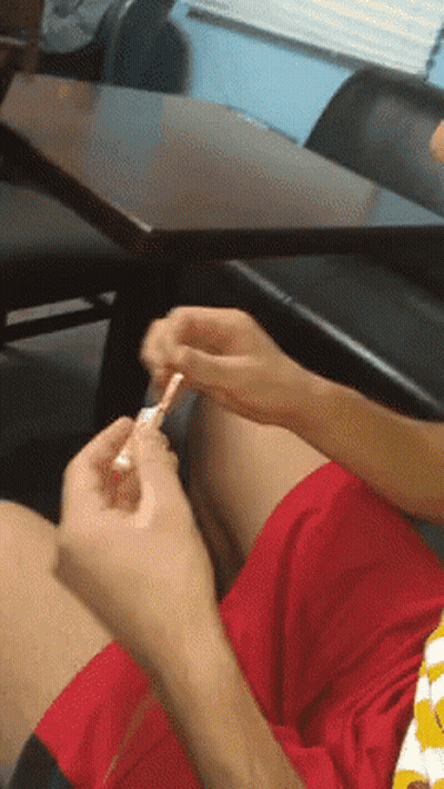 Person In Red Shorts Sitting At Table GIF