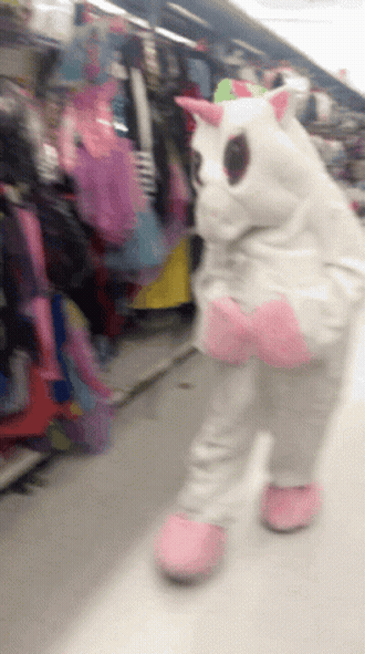 Person In Unicorn Costume Walking Down Store Aisle GIF