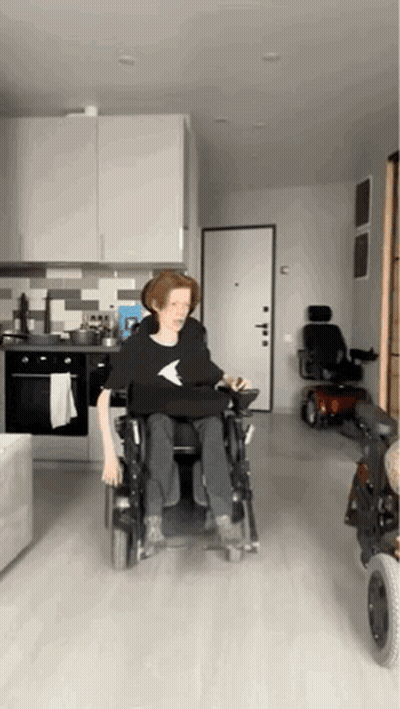 Person In Wheelchair In Kitchen With Scooter GIF
