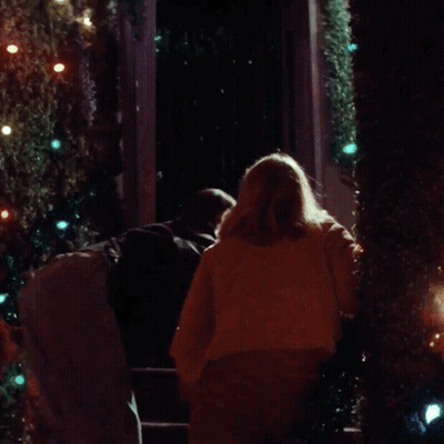 Person In White Mask In Front Of Christmas Tree GIF
