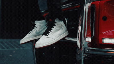Person In White Nike Sneakers Sitting On Red Car GIF