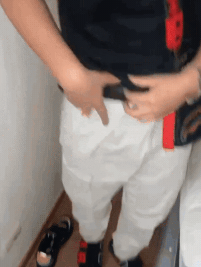 Person In White Pants And Black Shirt Holding Belt GIF