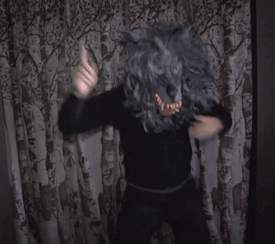 Person In Wolf Mask Standing In Front Of Curtain GIF