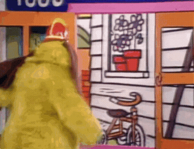 Person In Yellow Coat With Bicycle And House GIF