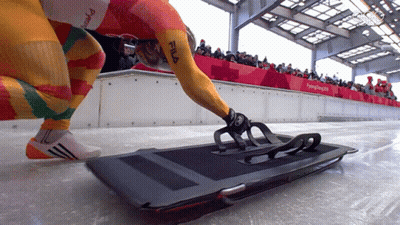 Person In Yellow Fila Shirt Kneeling On Sled GIF