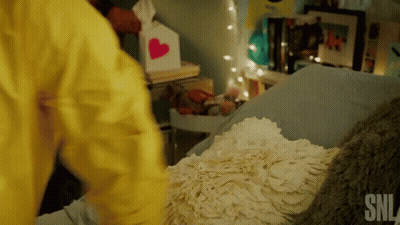 Person In Yellow Jacket Next To Bed GIF