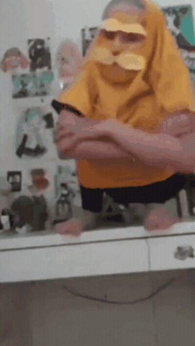 Person In Yellow Shirt With Mustache Sitting GIF