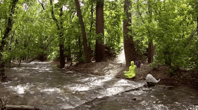Person In Yellow Suit Sitting On Rock In Stream GIF